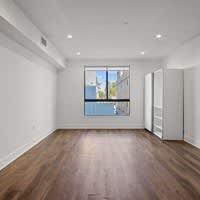 A room with a window and wooden floors.