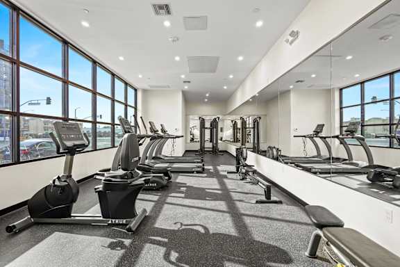A gym with treadmills, elliptical machines, and other exercise equipment.