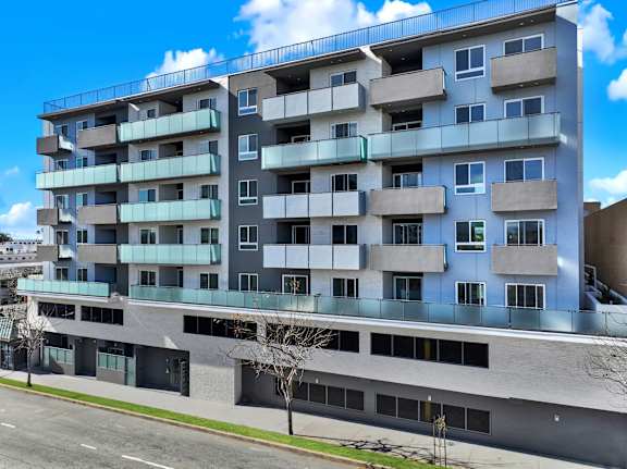 A modern apartment building with balconies and multiple floors.