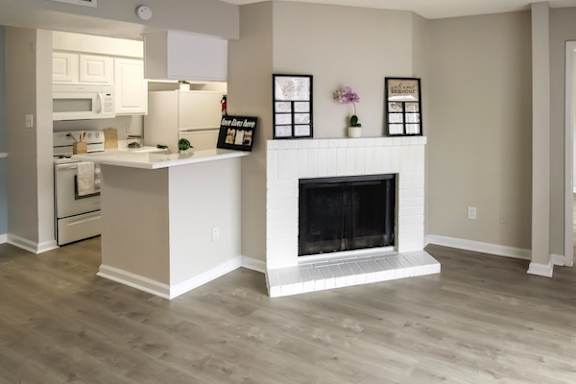 A kitchen with a white island and a fireplace. at Pine Creek Apartments, Texas