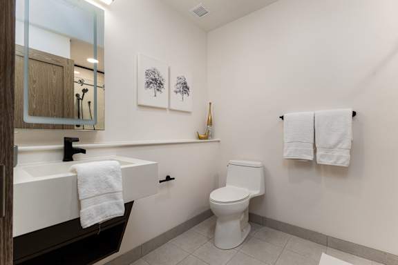 A white toilet sits next to a white sink in a bathroom.