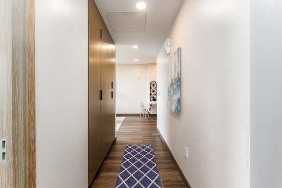 A hallway with a blue and white patterned rug on the floor.
