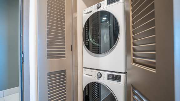 A stack of three washing machines in a laundry room.