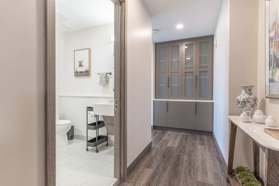 A bathroom with a toilet, sink, and a cabinet.