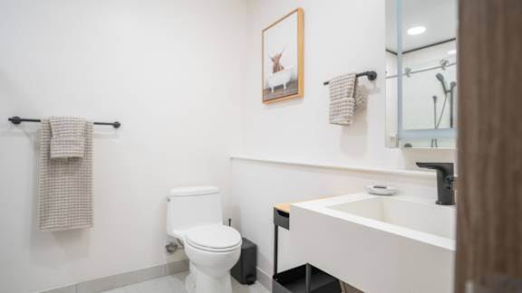 A white toilet sits next to a white sink in a bathroom.