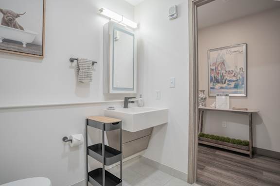 A bathroom with a white sink and a mirror above it.