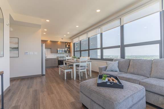 A modern living room with a grey couch and a wooden floor.