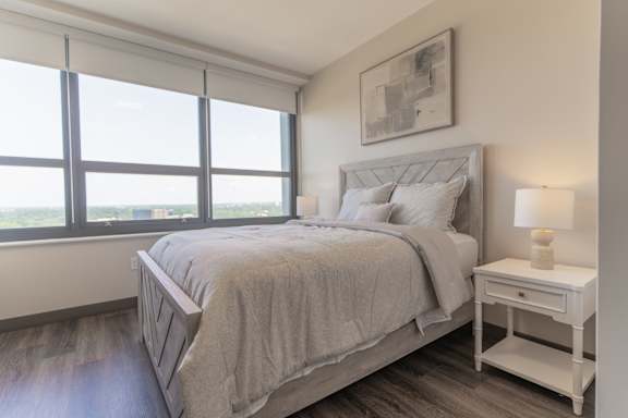 A bedroom with a large bed and a window overlooking the ocean.