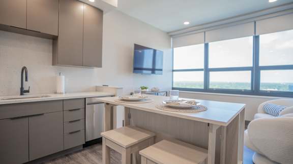 A modern kitchen with a dining table and chairs.