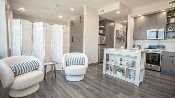 A modern kitchen with a breakfast bar and two chairs.
