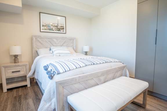 A bedroom with a large bed and a bench.