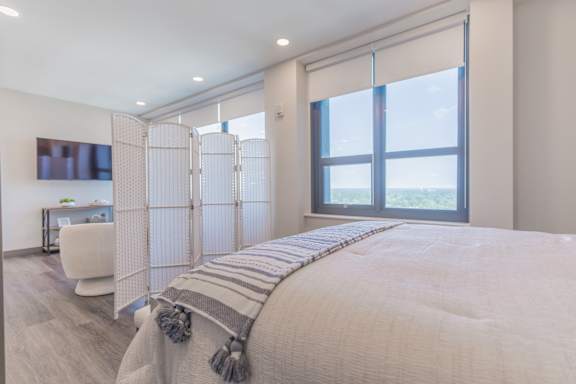 A bedroom with a large bed and a chair.