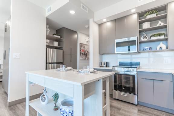 A modern kitchen with a white table and stainless steel appliances.