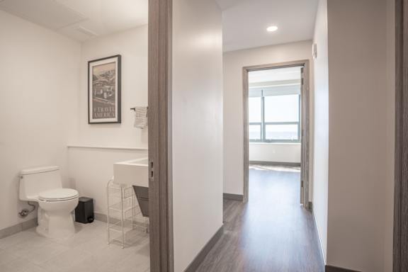 A bathroom with a toilet, sink, and a picture on the wall.
