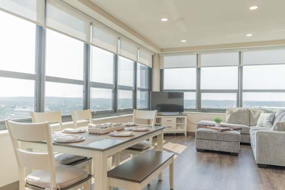 A modern dining room with a table set for six and a view of the city.