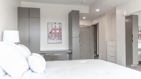 A modern bedroom with a large bed and a painting on the wall.