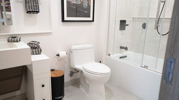 A white toilet sits in a bathroom next to a white sink.