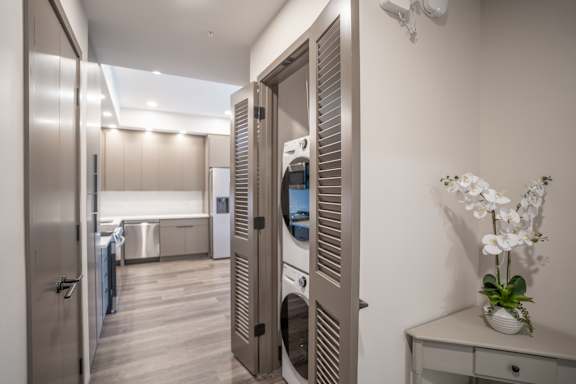 A modern kitchen with a washing machine built into the cabinetry.
