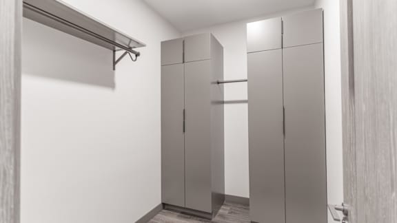 A white room with a row of cupboards and a shelf.