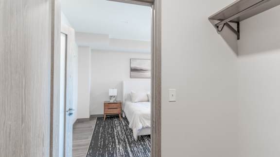 A bedroom with a bed, nightstand, and lamp.