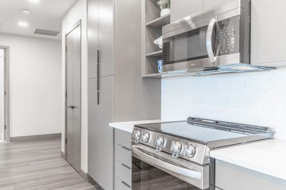 A modern kitchen with a stove top oven and a microwave above it.