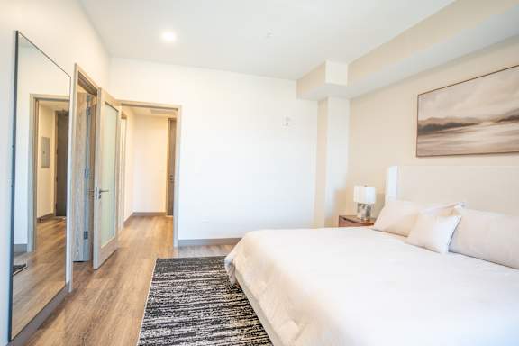 A bedroom with a large bed and a painting on the wall.