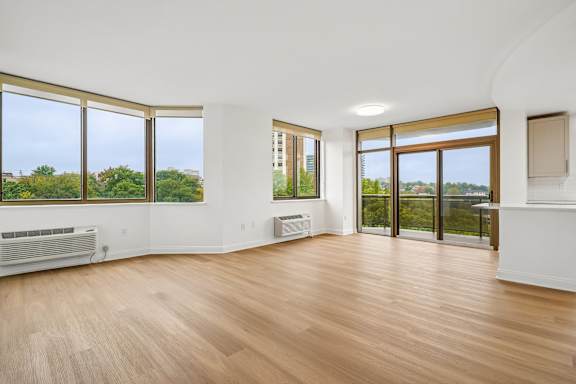 A room with wooden floors and large windows.
