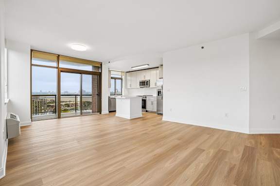 A spacious room with wooden floors and white walls.