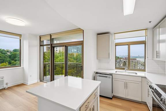 A kitchen with a large island and a view of the city.