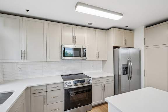 A kitchen with white cabinets and appliances.