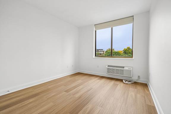 A room with a window and a heater.