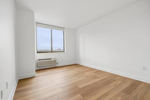 A room with a window and a heater.
