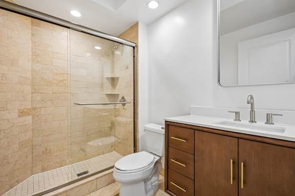 A bathroom with a toilet, sink, and shower.