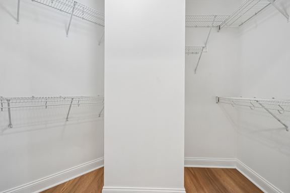 A white wall with a row of clothes hangers.