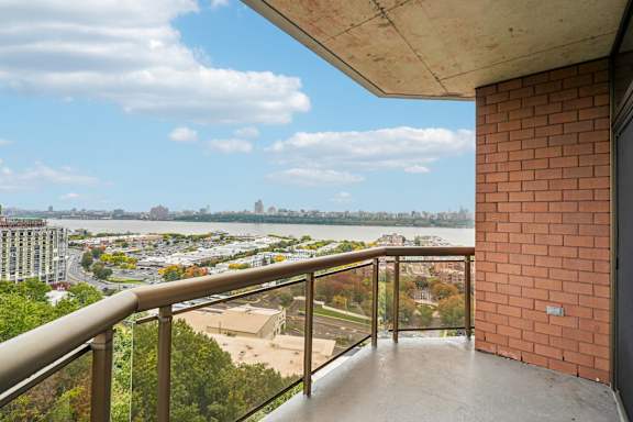 A balcony with a view of a cityscape and a body of water.