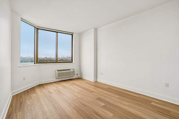 A room with a window and a radiator on the floor.