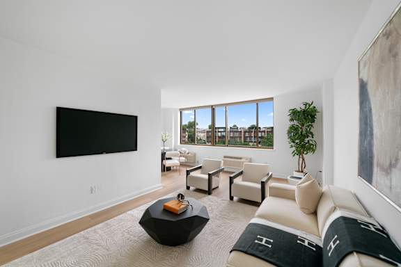 A living room with a large couch, a coffee table, and a flat screen TV.