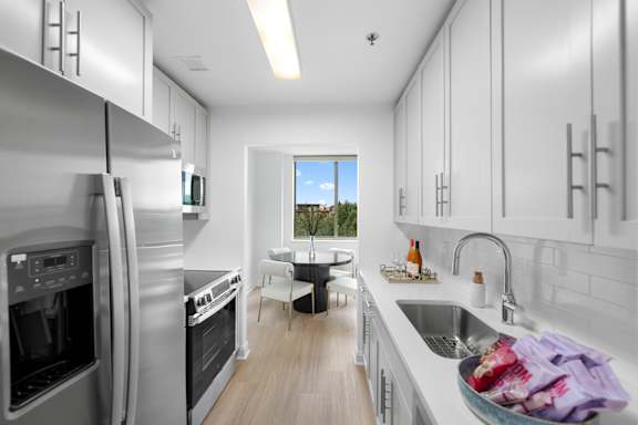 A modern kitchen with a view of the outdoors through a window.