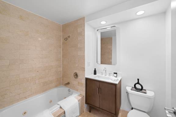 A bathroom with a tub, toilet, and sink.