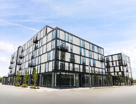 A modern multi-story building with black and white balconies.