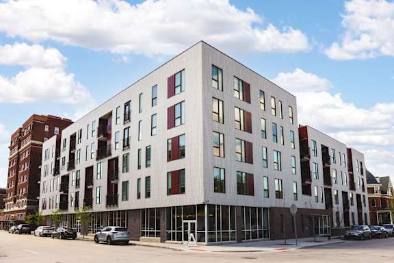 A modern building with a white facade and red and green accents.