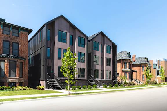 A row of modern buildings with a clear blue sky above them.