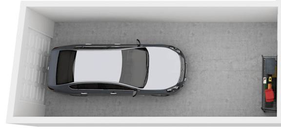 A car is parked in a white-walled garage.