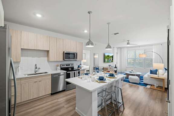 A modern kitchen with a dining area and a view of the backyard.