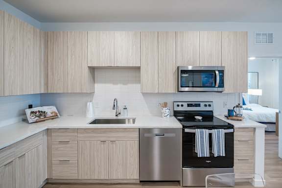 A modern kitchen with wooden cabinets and stainless steel appliances.