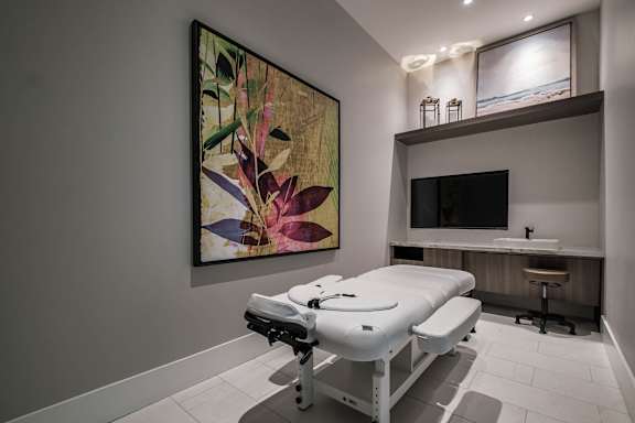 A room with a massage table and a painting on the wall at Altis Santa Barbara, Florida