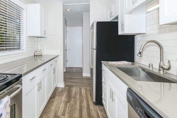 a kitchen with white cabinets and a black refrigerator