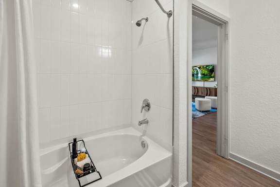 A white bathroom with a white tub and a white shower curtain.