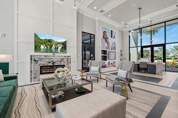 A modern living room with a green sofa, a coffee table, and a large TV displaying a nature scene.