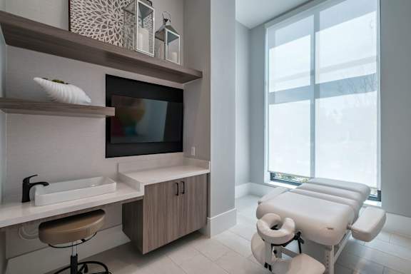 a treatment room at a hospital with a large window and a sink and a chair at Altis Twin Lakes Apartments, Kissimmee, FL 34744